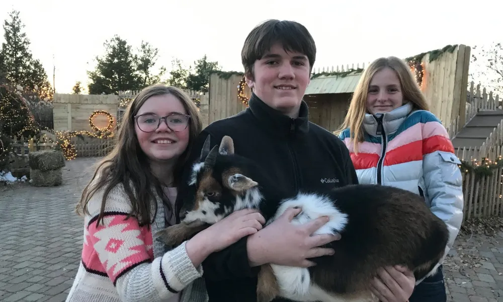 Children holding goat at Christmas Corner at Grand Cascades Lodge