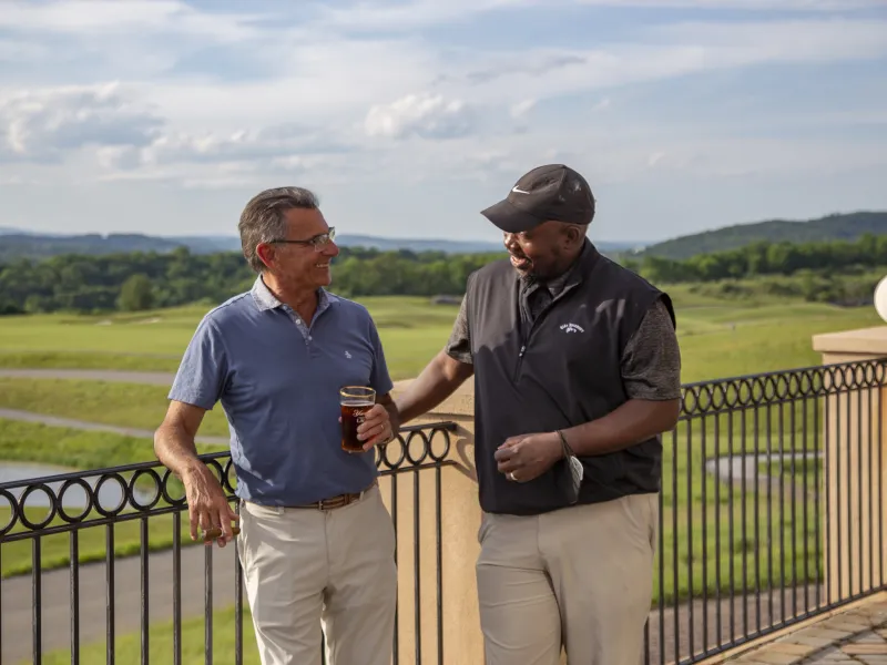Guys enjoying drinks on the outdoor patio of a golf club at Crystal Springs Resort